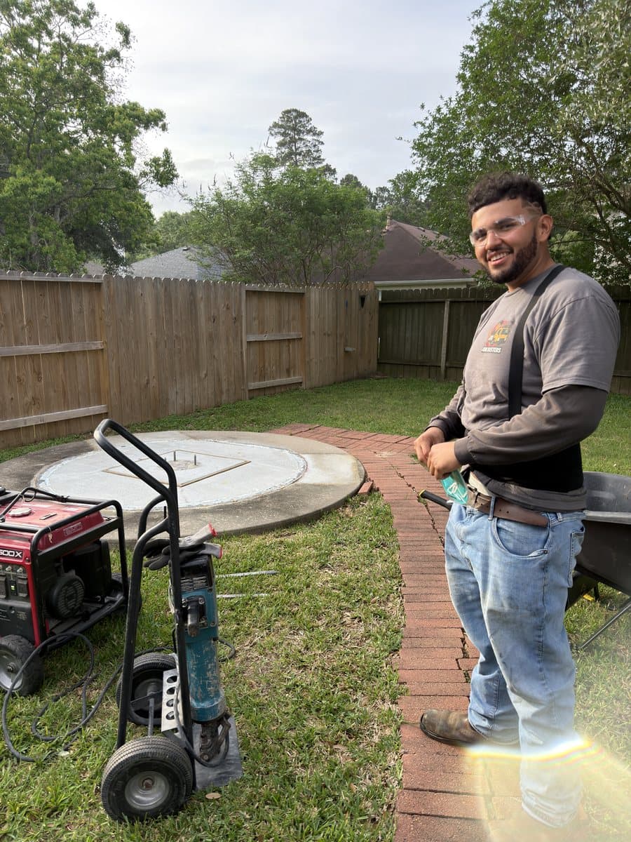 Real job photo of a Junk Busters team member standing next to a broken-out concrete slab ready for haul-away in Houston