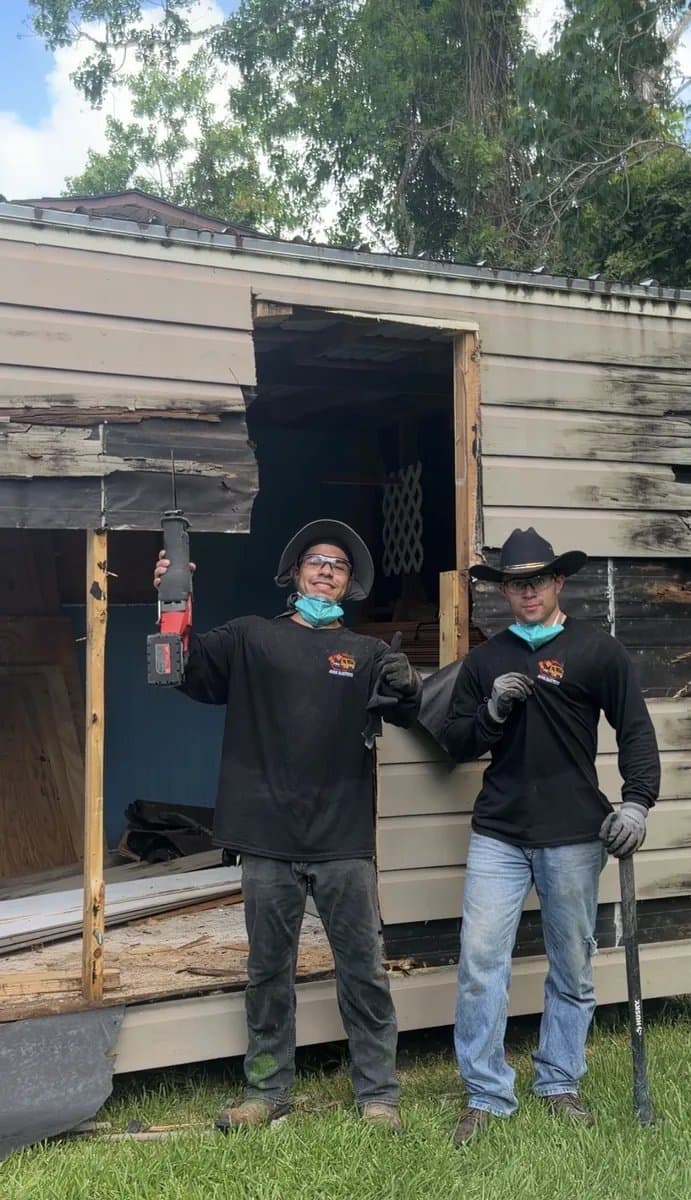 Real before photo of a weathered backyard shed scheduled for demolition on a grassy Houston lot